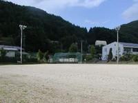 建物と夜間用ライトが写り込む川島小学校校庭の写真