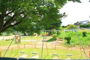公園にある4つの椅子が並ぶブランコの写真