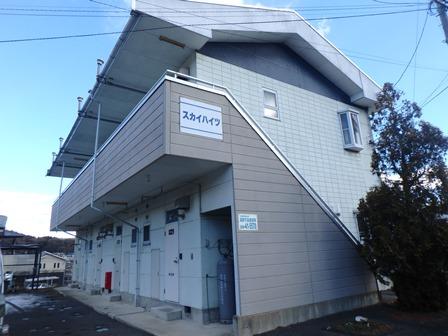 スカイハイツの看板が貼ってある2階建てのアパートの画像