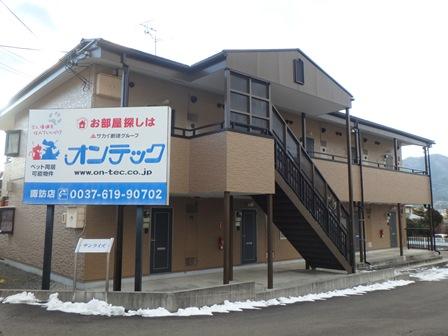 角にオンテックの看板が立っている2階建てのサンライズの写真