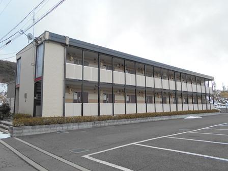 横に9部屋も並んだ2階建てのレオパレス平出の駐車場側からの写真