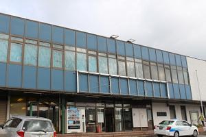 青をベースとした壁面とガラス張りの辰野駅の正面画像