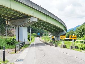陸橋の下を通る道を行く