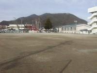 山を背景にした辰野西小学校校庭の写真