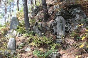 岩場に並ぶ七曲の石神仏の写真