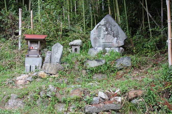 竹林の中に小さな祠と石碑などがいくつか並んでいる写真