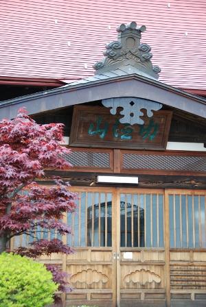 赤っぽい屋根のほたる寺伝福寺の玄関の写真