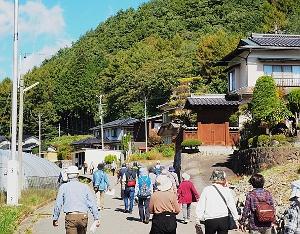 12人以上の年配の方々が少し上り坂になっている道を上がっている写真